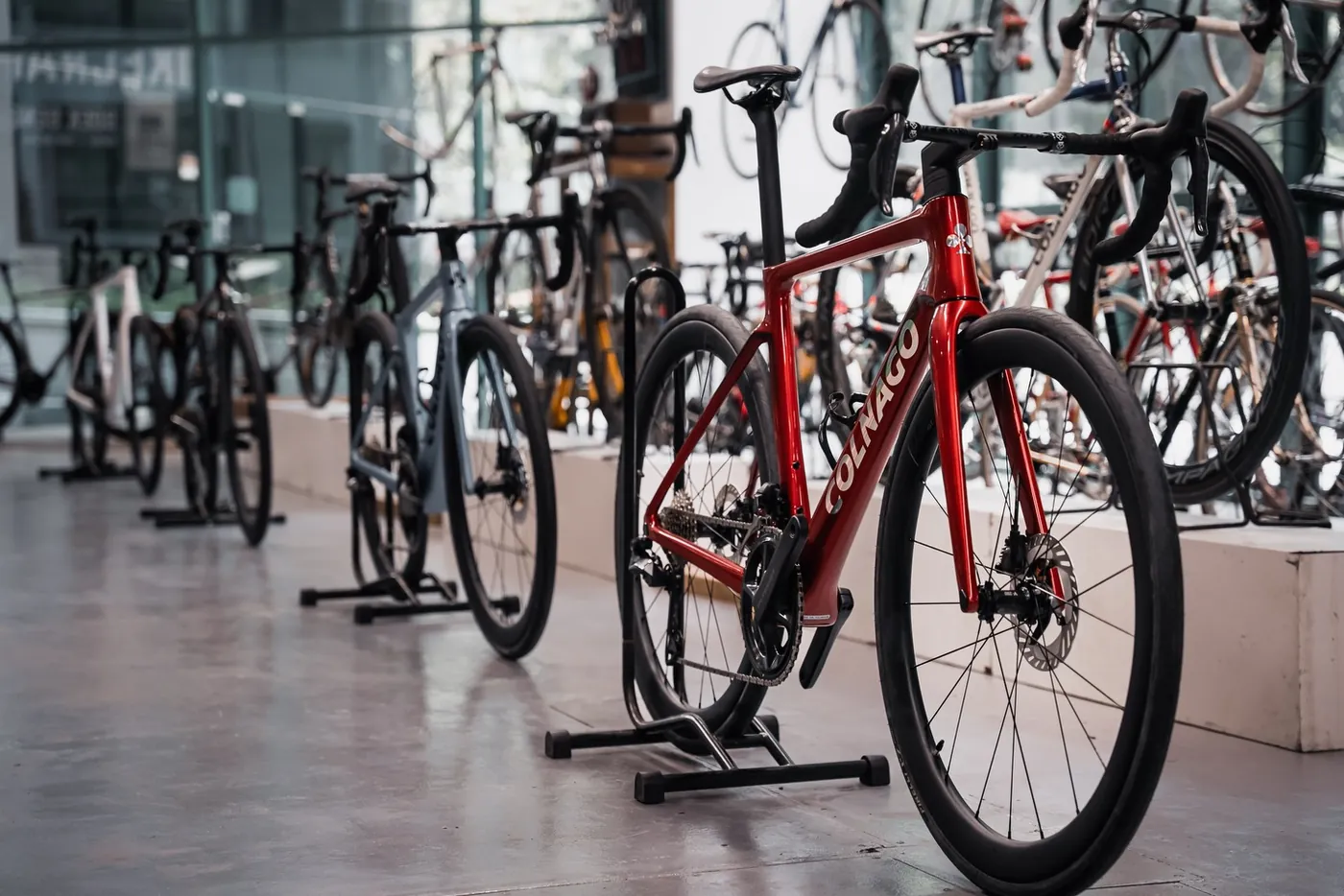 A red Colnago road bike on a stand in the BikeCraft One showroom